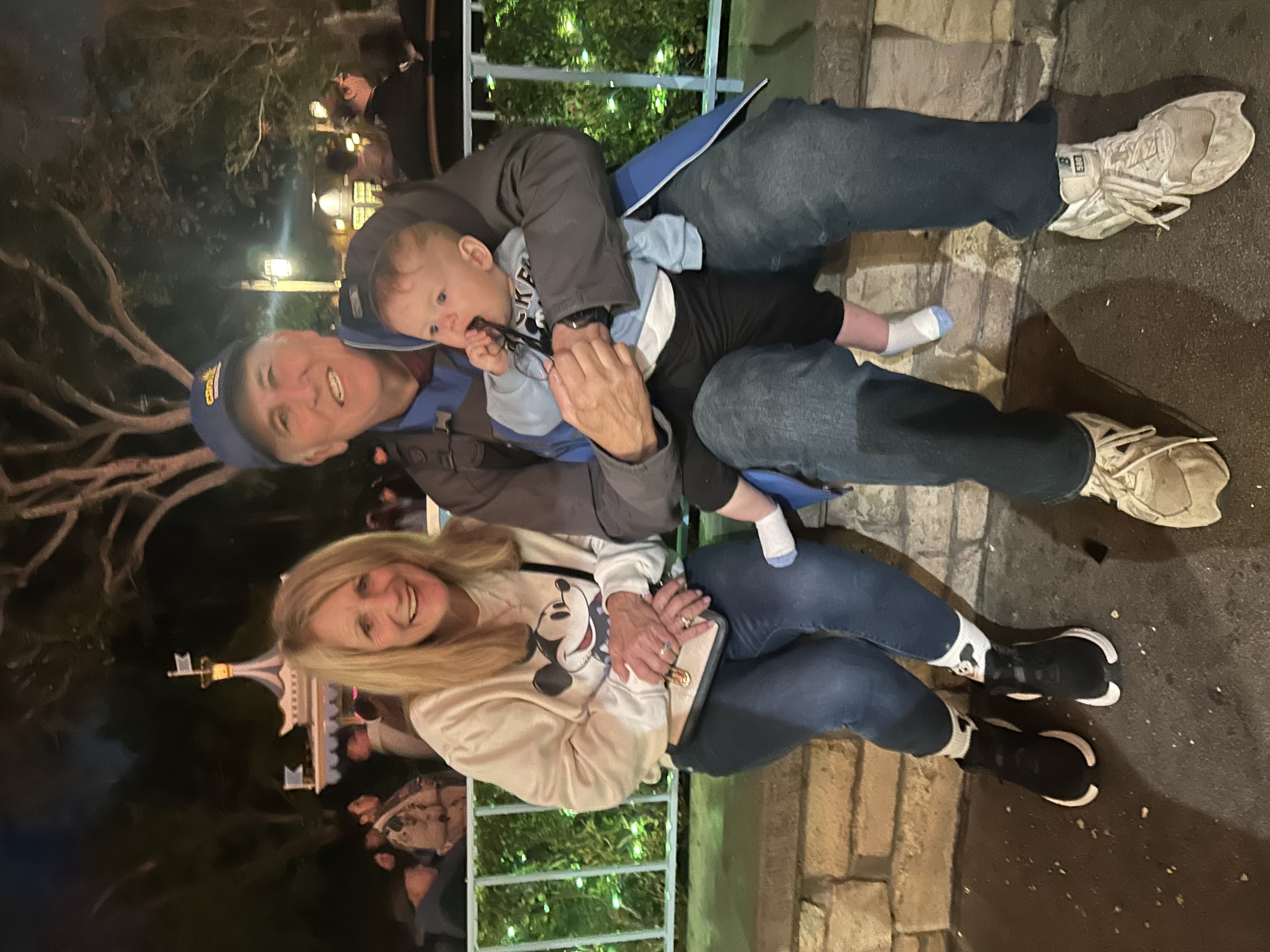 David and Libby with grandchild at Disneyland